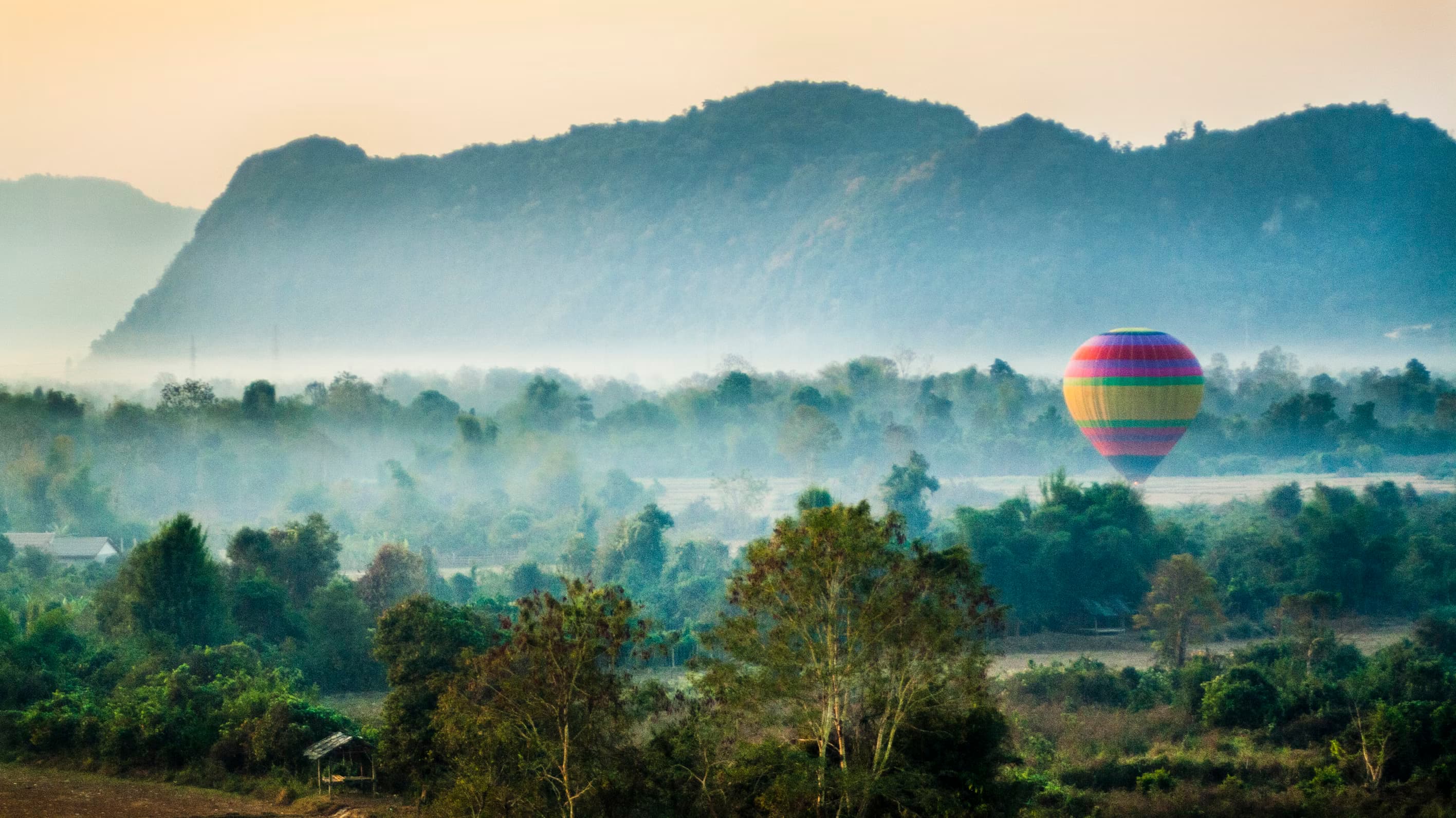 Paysage verdoyant du Laos avec rizières et montagnes embrumées